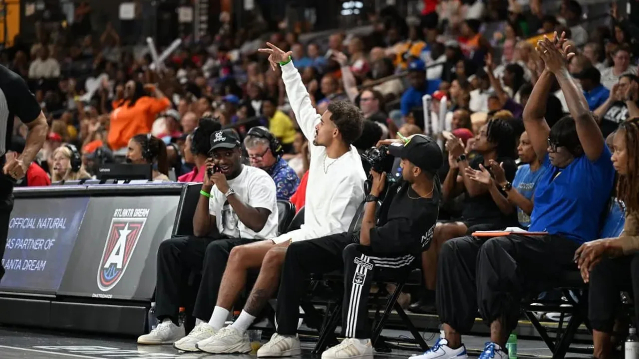 Atlanta Dream fan celebrating from a courtside seat during a WNBA game